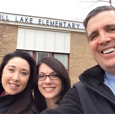 Doctor Jay McCarl and two dental team members outside of Springhill Lake Elementary School