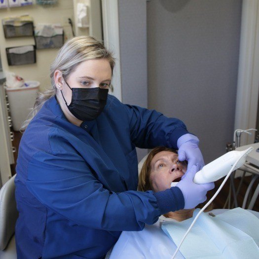 Dental team member taking digital scans of a patient