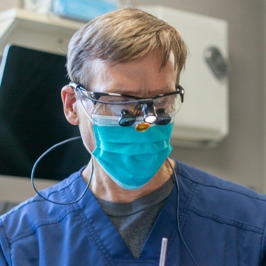 Dentist wearing face mask and dental binoculars