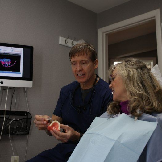 Dentist showing a model of the teeth to a patient