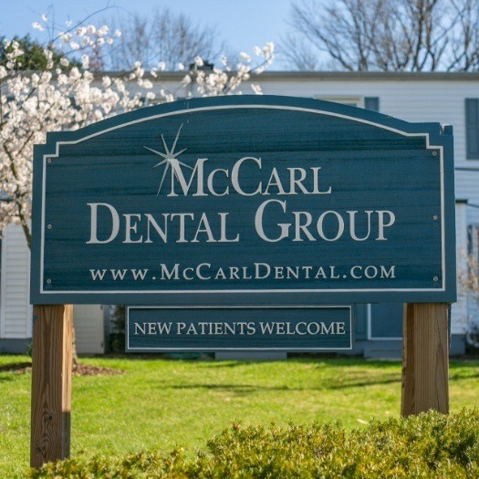 Team members by McCarl Dental Group sign