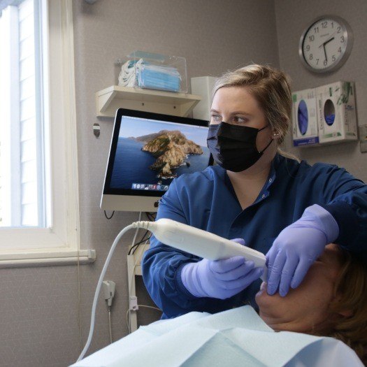 Dental team member using an intraoral camera on a patient