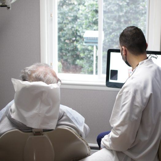 Dentist showing a computer monitor to a patient
