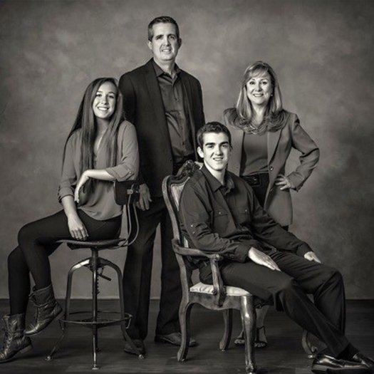 Doctor Jay McCarl smiling with his wife and two grown children