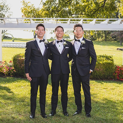 Doctor Lam with two other men in tuxedos at a wedding