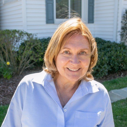 Woman in white buttoned shirt smiling outdoors