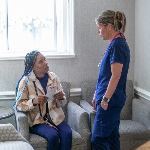 Woman in a chair talking to dental team member