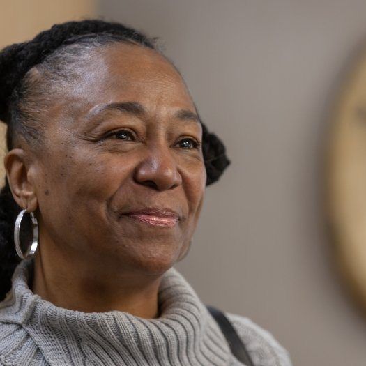 Woman in gray sweater smiling after gum disease treatment