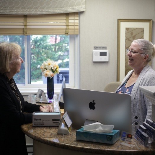 Woman talking to dental office receptionist