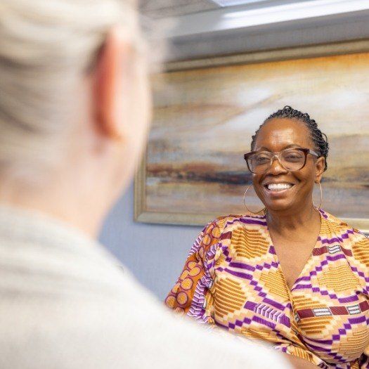 Woman in dental office smiling at dental team member