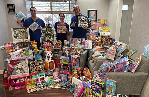 Dental team members in room full of toys to be donated