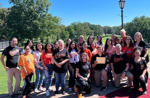 Dental team members standing outdoors in Orioles jerseys