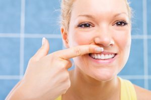 Woman looking at her gum in the mirror