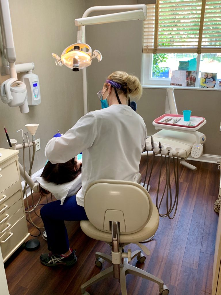 Dental hygienist treating dental patient