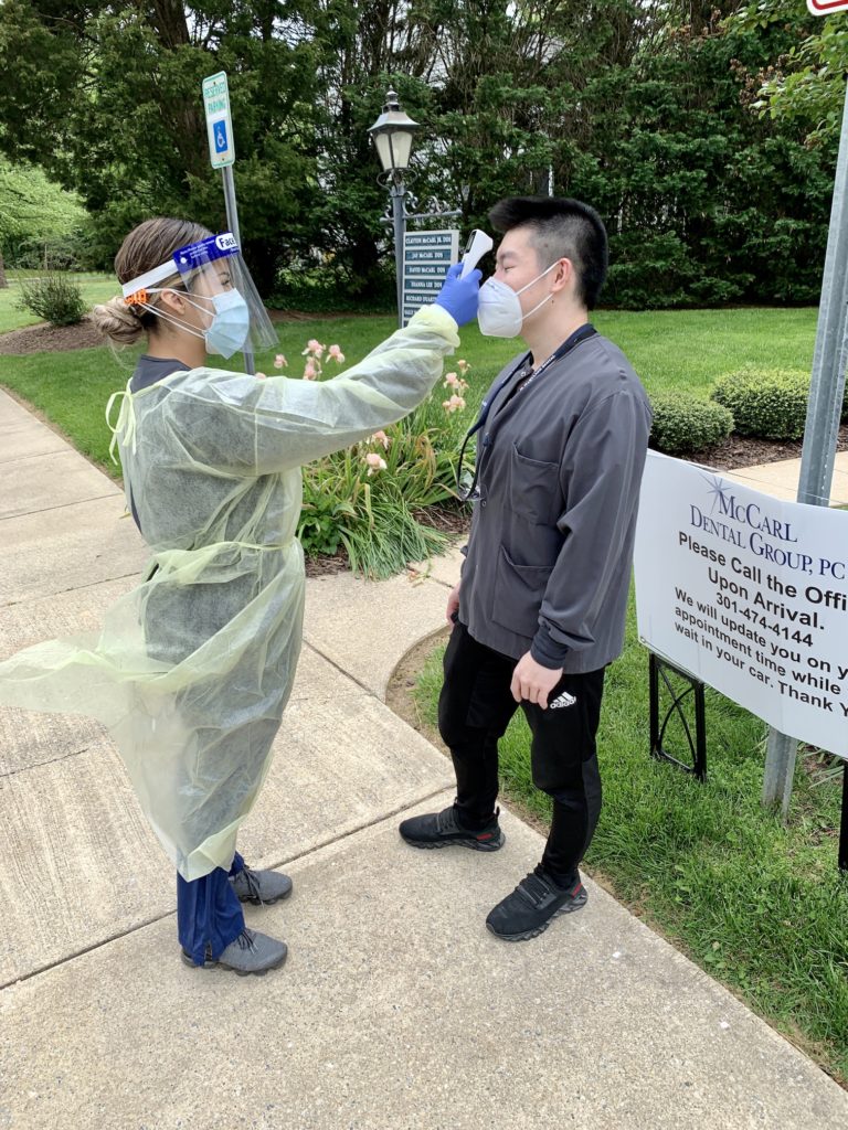 Dental team member taking patient's temperature